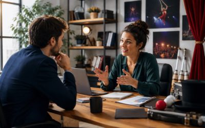 Séance de coaching professionnel entre un entrepreneur du spectacle et sa consultante, autour d'une stratégie de développement commercial dans un bureau