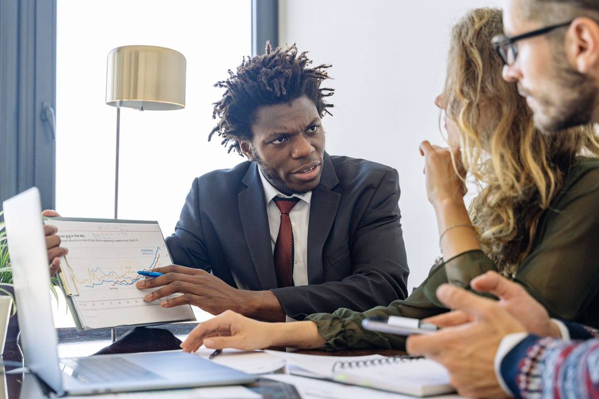 Réunion professionnelle avec ordinateur, graphique, smartphone et notes sur la table