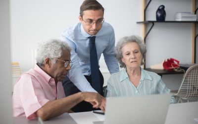 Groupe mixte consultatif autour d'un ordinateur portable dans un environnement de bureau