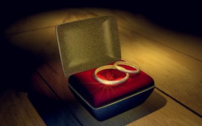 Deux bagues d'or reposent sur un coussin rouge dans une boîte à bijoux