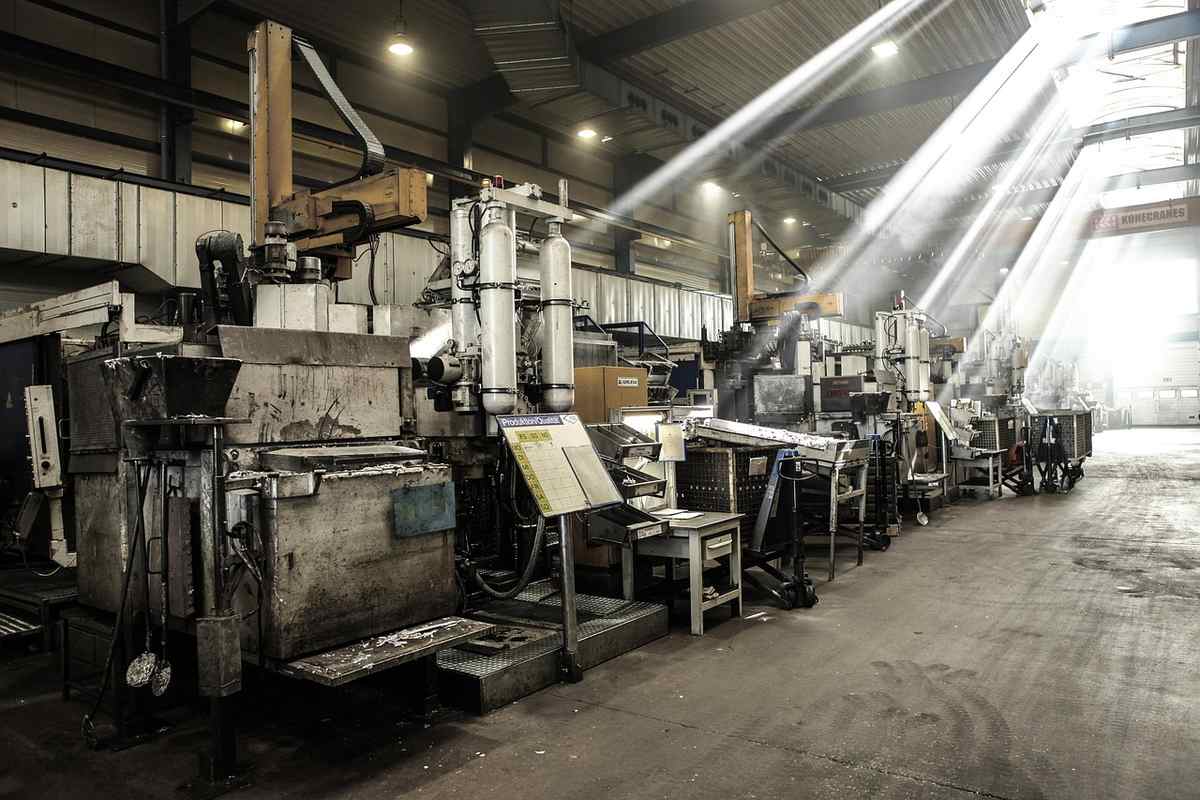 Grande salle d'usine contenant plusieurs machines industrielles en fonctionnement Grande salle d'usine contenant plusieurs machines industrielles en fonctionnement