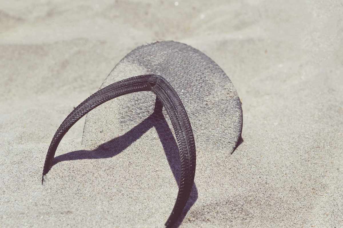 Des sandales de plage et une serviette sur une terrasse Des sandales de plage et une serviette sur une terrasse