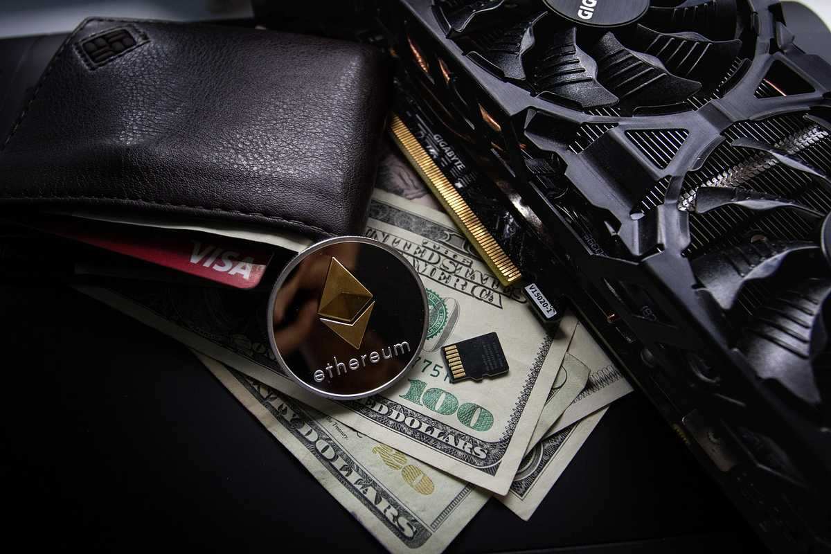 Portefeuille avec carte de crédit, jeton Ethereum, fan de PC, microprocesseur et billets de 100 dollars