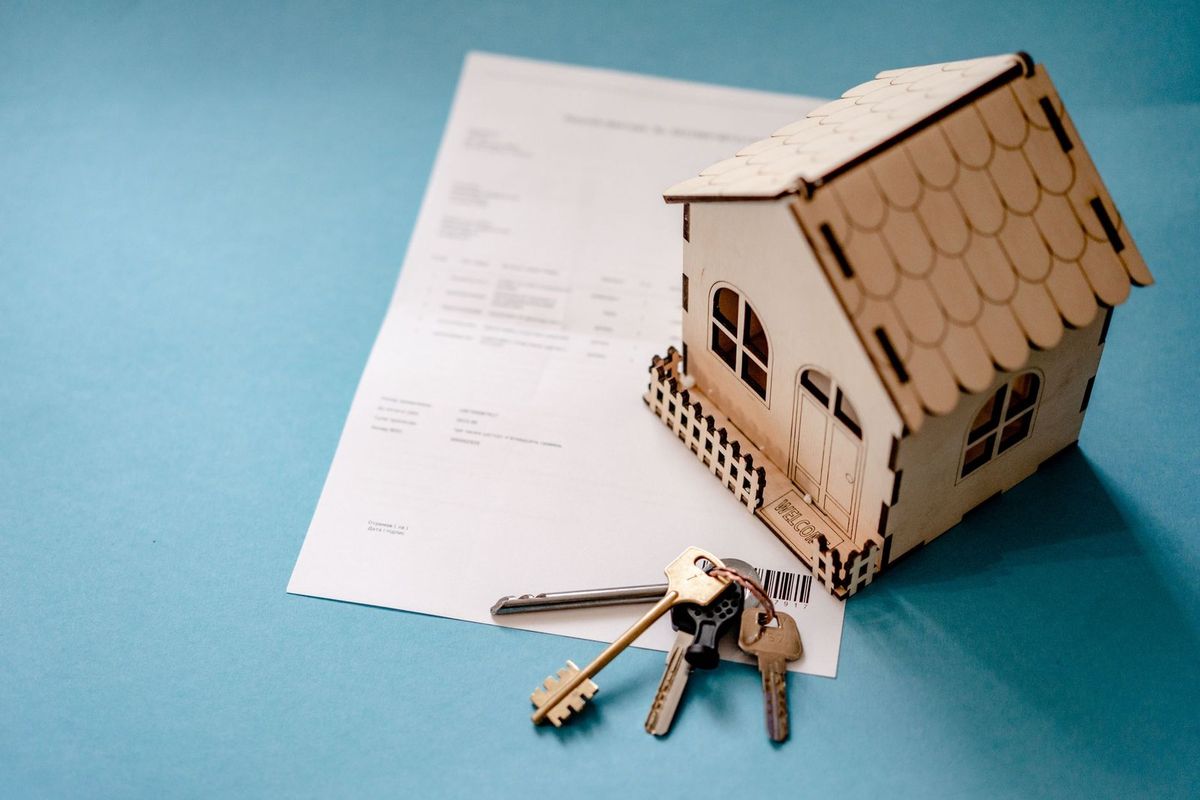 Maison en carton, clés et document sur fond bleu Maison en carton, clés et document sur fond bleu