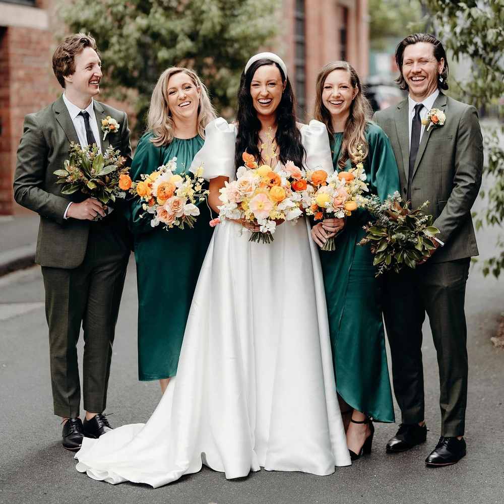 Mariage civil ou religieux, couple souriant, invités en vert et gris, fleurs colorées Mariage civil ou religieux, couple souriant, invités en vert et gris, fleurs colorées